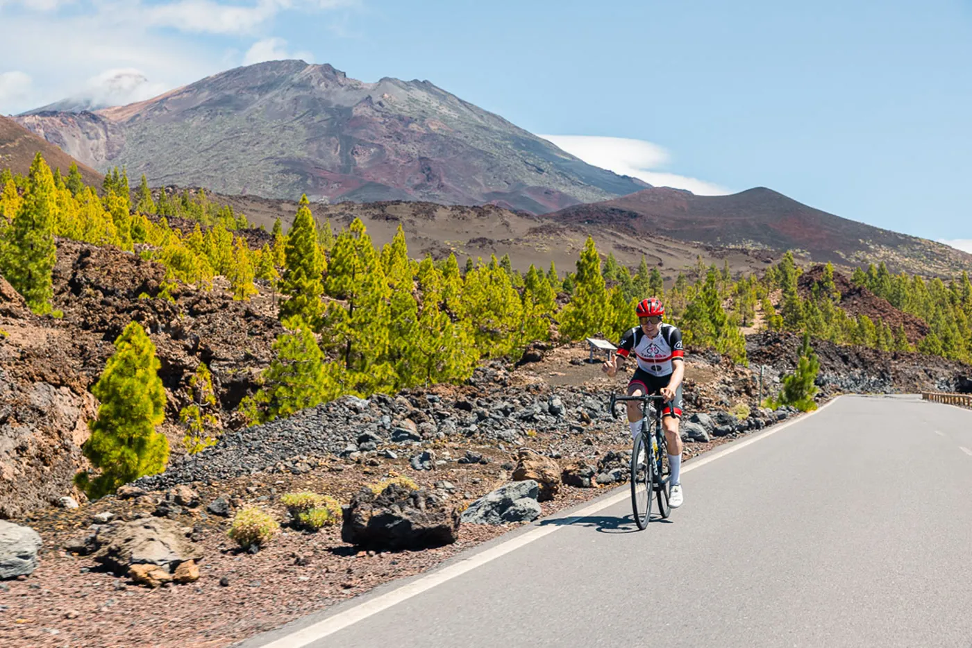 Ciclista de carretera subiendo con el Teide al fondo