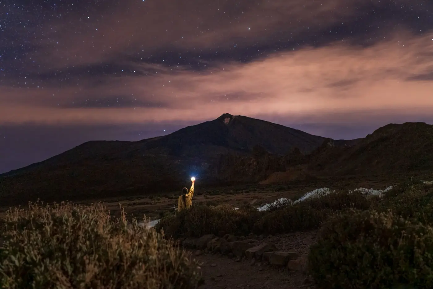 Persona observando el cielo estrellado junto al Teide de noche