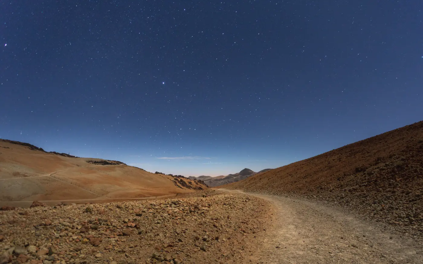 Sendero volcánico bajo un cielo estrellado en el Teide