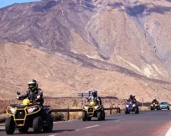 Grupo de quads circulando por carretera con el Teide al fondo